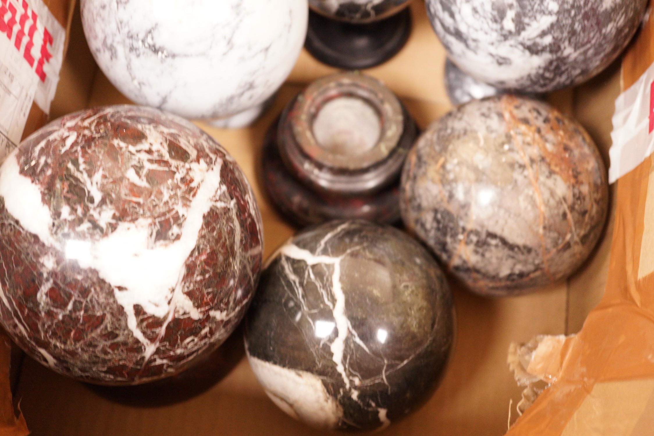 A quantity of carved marble balls on stands